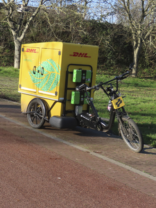 908514 Afbeelding van een transportfiets van koeriersbedrijf DHL, geparkeerd bij een plantsoentje aan de Zandweg ter ...